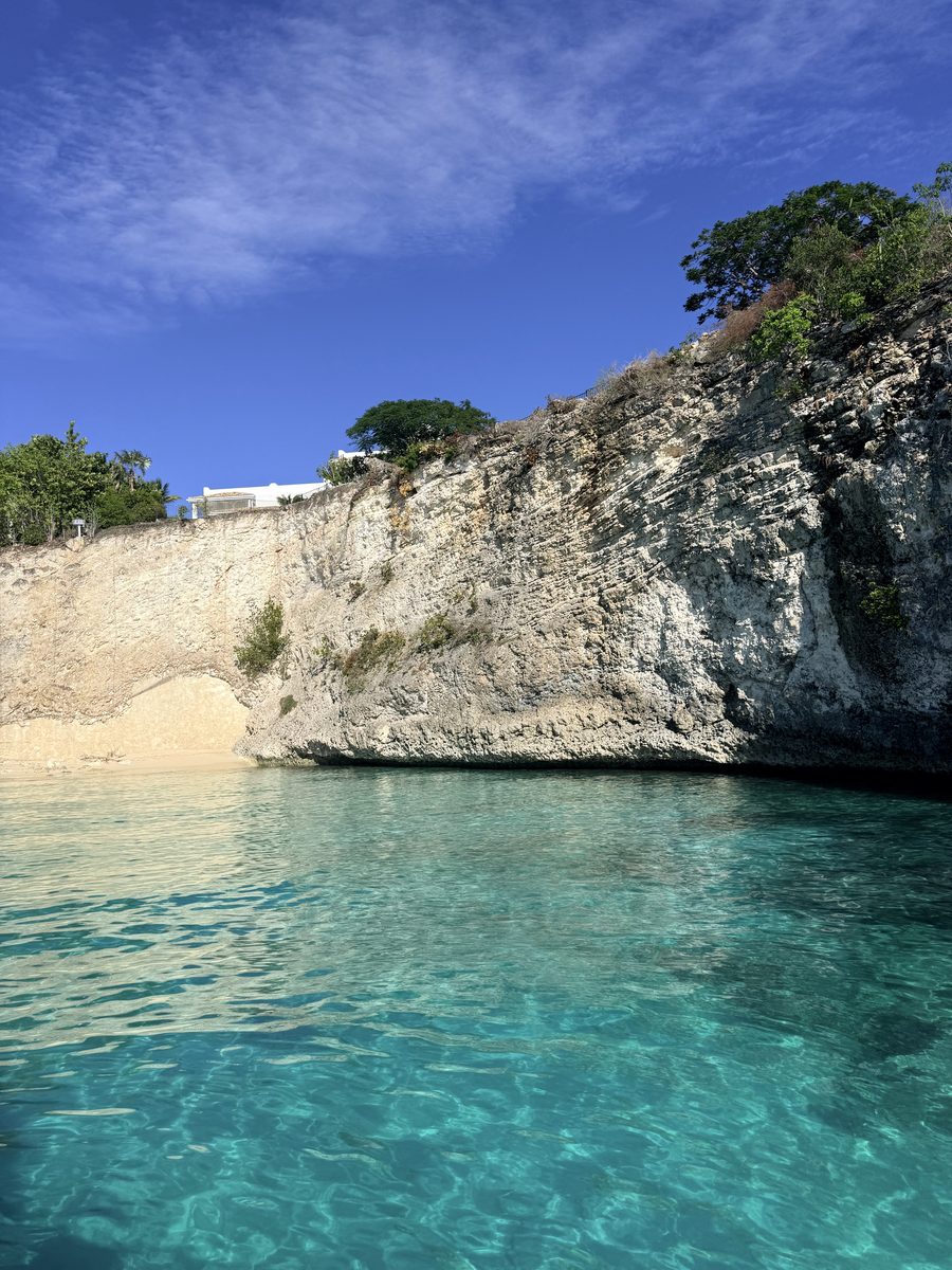 The cliff at La Samanna dropping into clear water at the end of Baie Longue, Saint-Martin