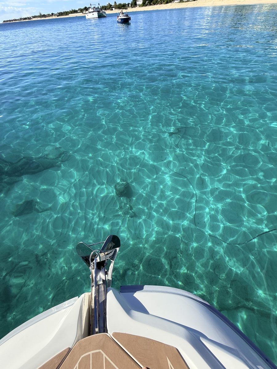Clear water over the sand, seen from the bow of the RIB at anchor off La Samanna